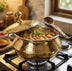 Brass pot on wooden trivet with hand ladling lentil soup into bowl at dinner table